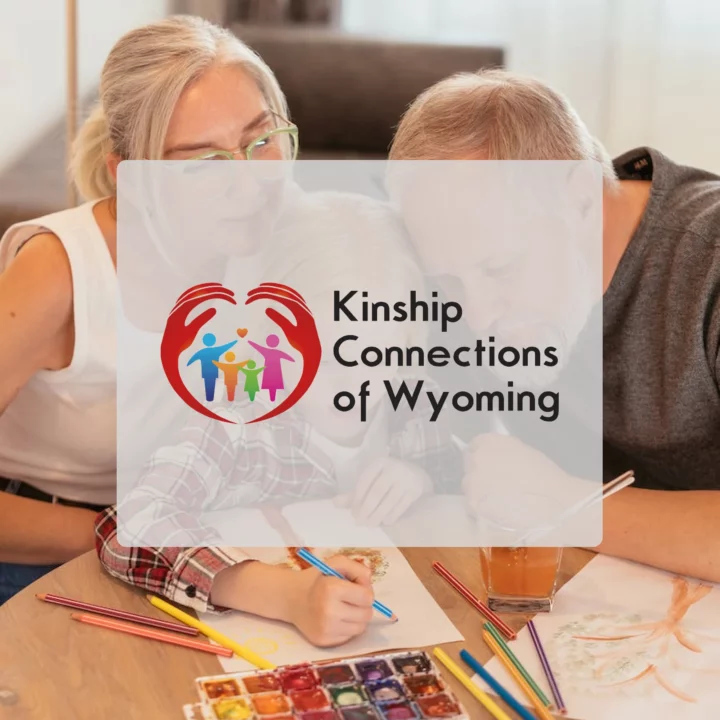 Grandparents playing to grandchild with Kinship connections of Wyoming logo in front