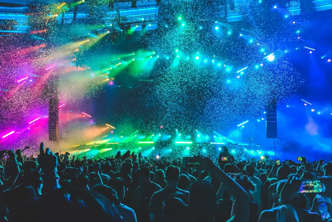 events image used as the hero image on wyoming 211 page. Pictured are a group of people attending a concert with confetti and rainbow colored lights