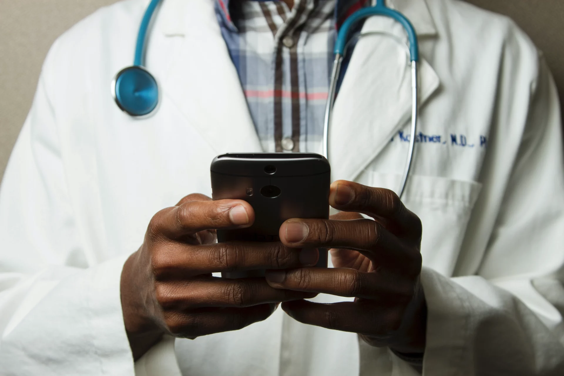 Doctor Holding Cell Phone. Cell phones and other kinds of mobile devices and communications technologies are of increasing importance in the delivery of health care.