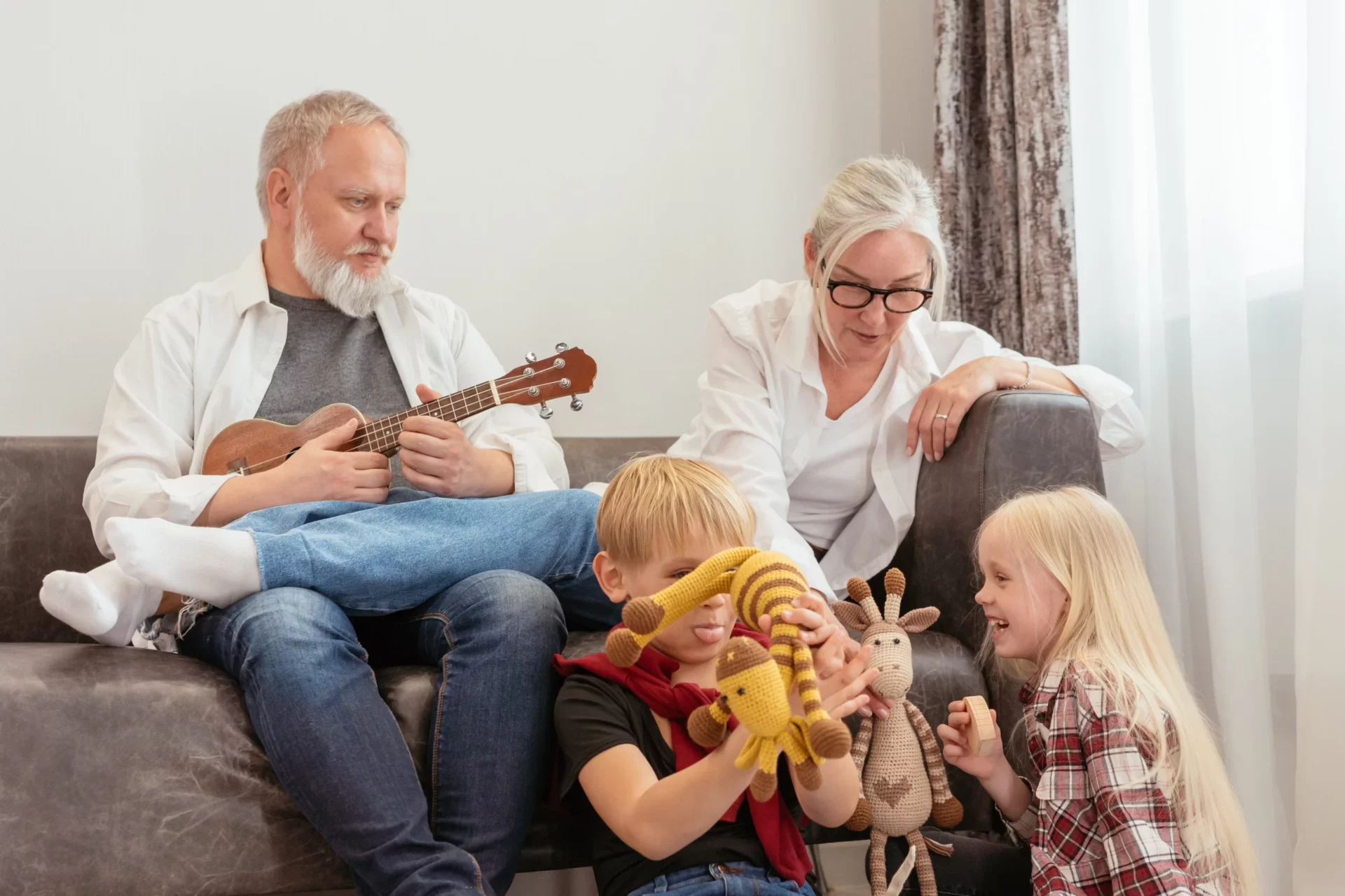 Grandparents help play with children in the living room
