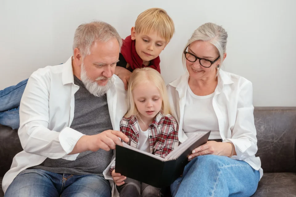 Grandparents reading to children in the living room